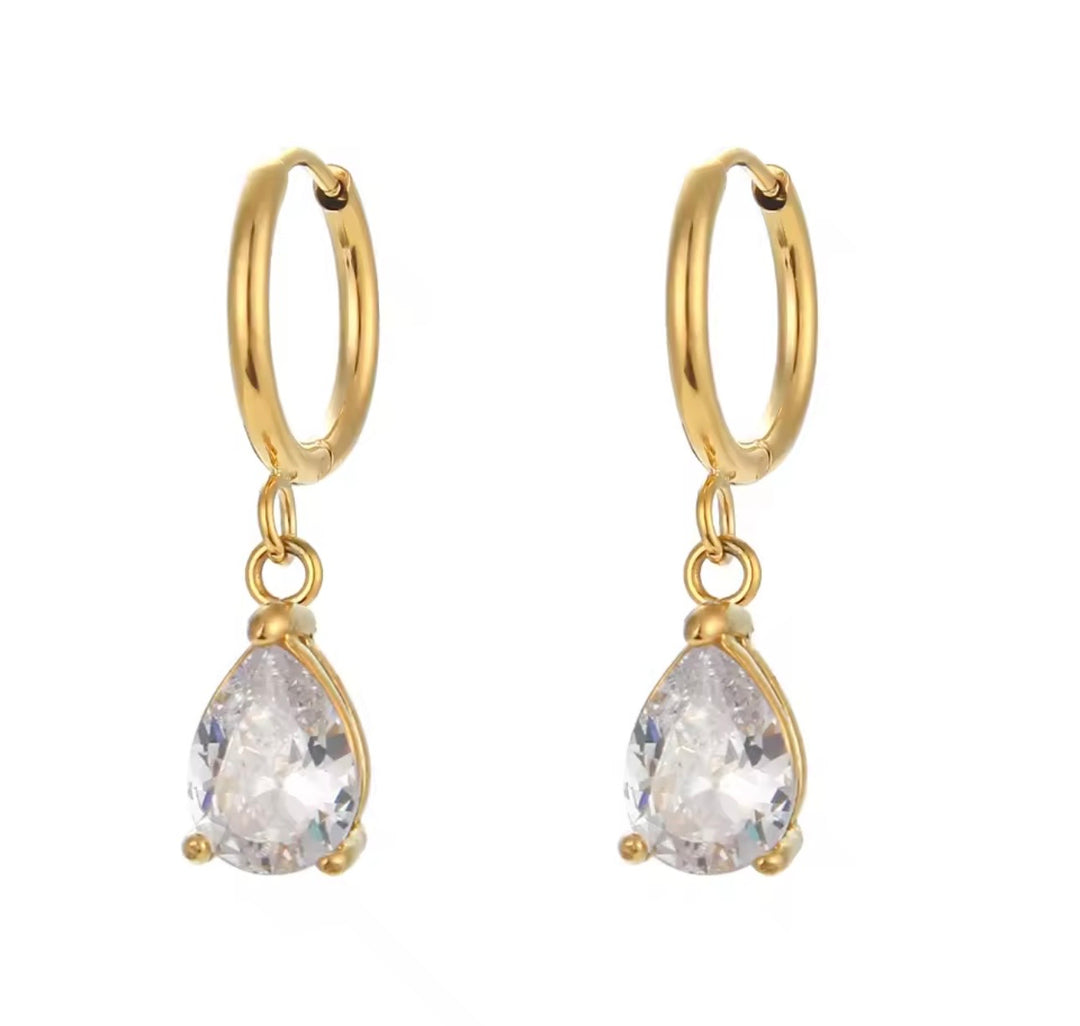 a pair of gold hoop earrings with a teardrop shaped diamond