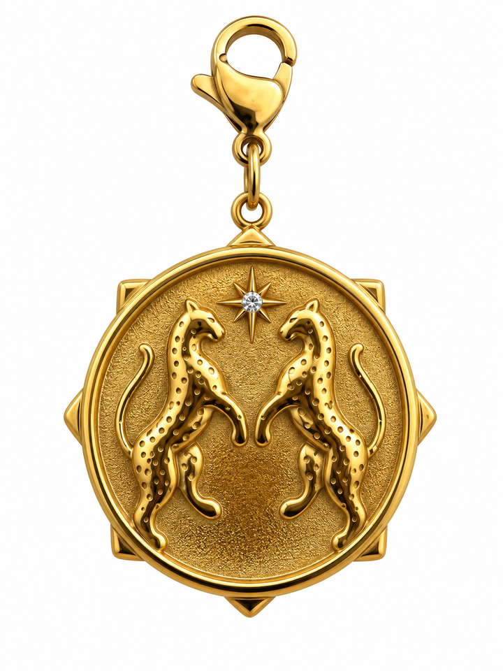 a gold pendant with a diamond and leopards