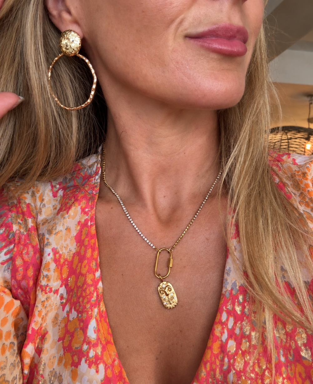 a woman wearing a necklace and earrings