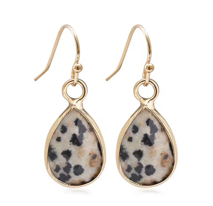 a pair of earrings with a stone in the middle