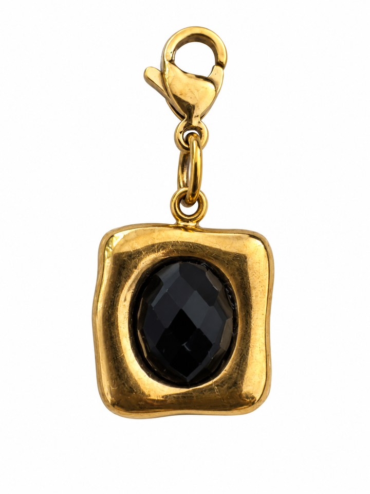 a gold necklace with a black stone
