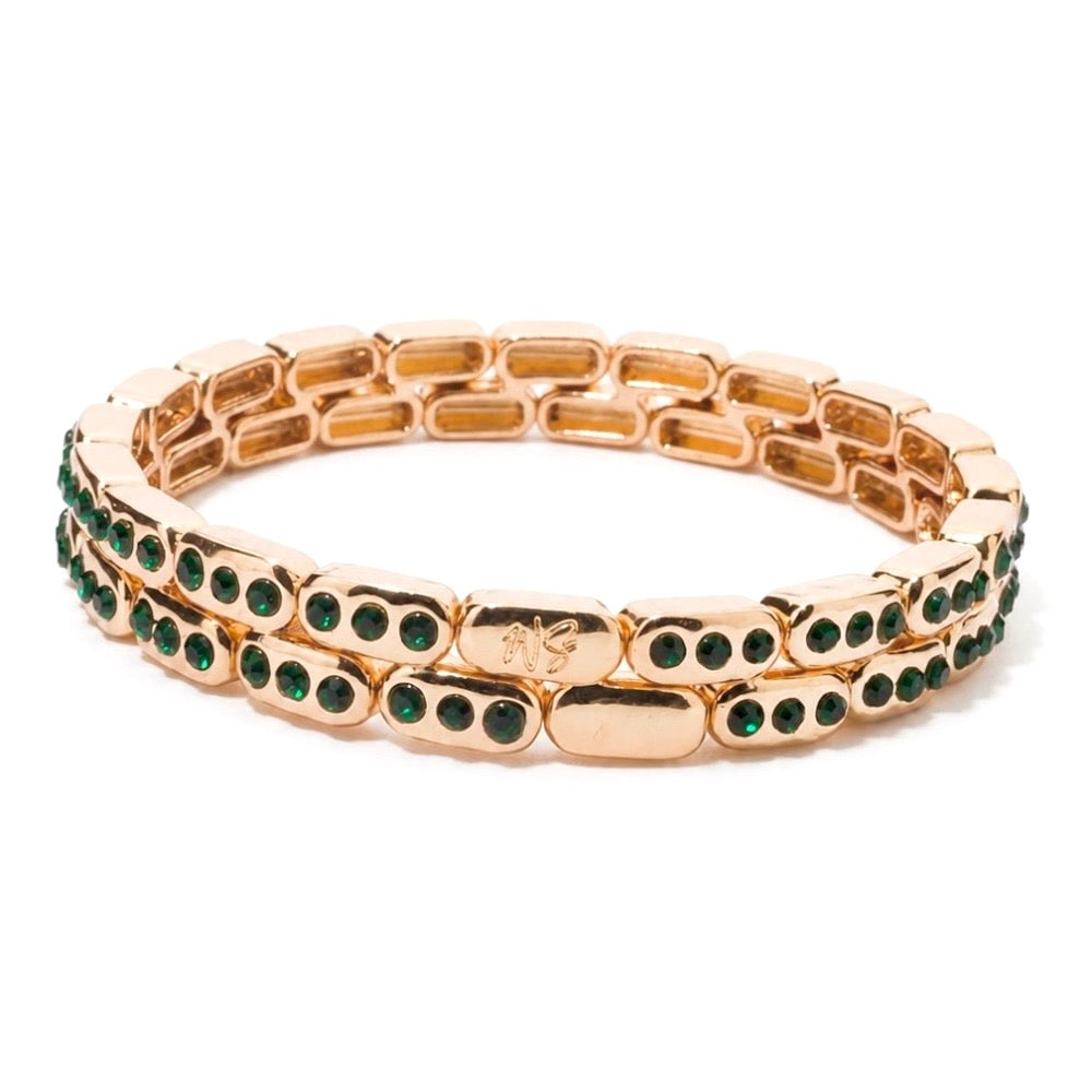 a gold bracelet with green stones
