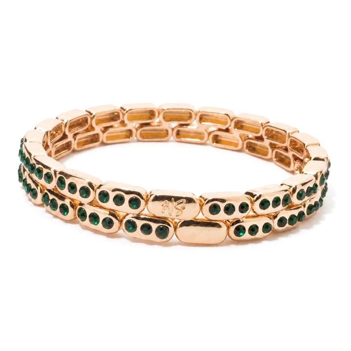 a gold bracelet with green stones