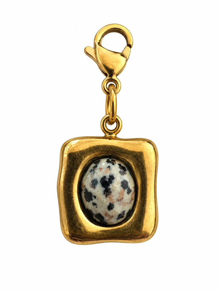 a gold square with a stone in it