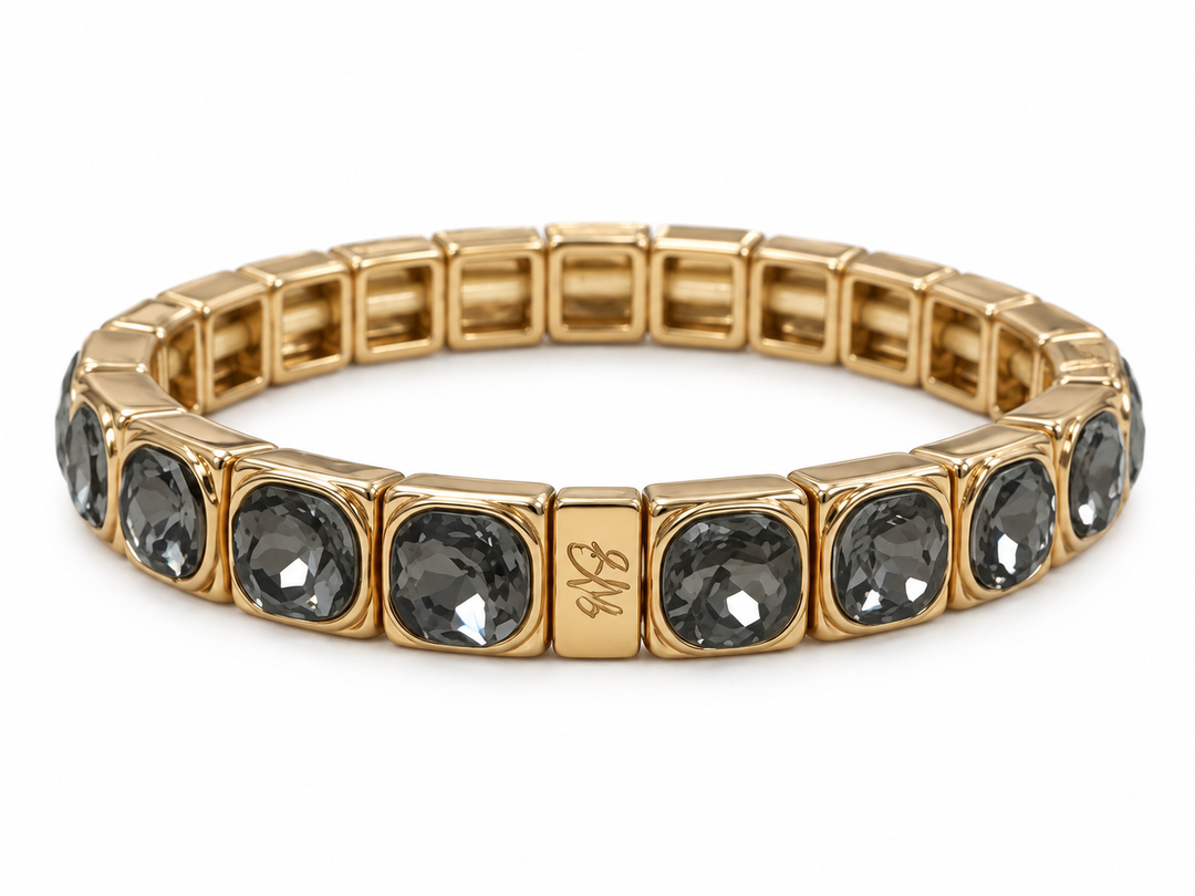 a gold bracelet with black stones