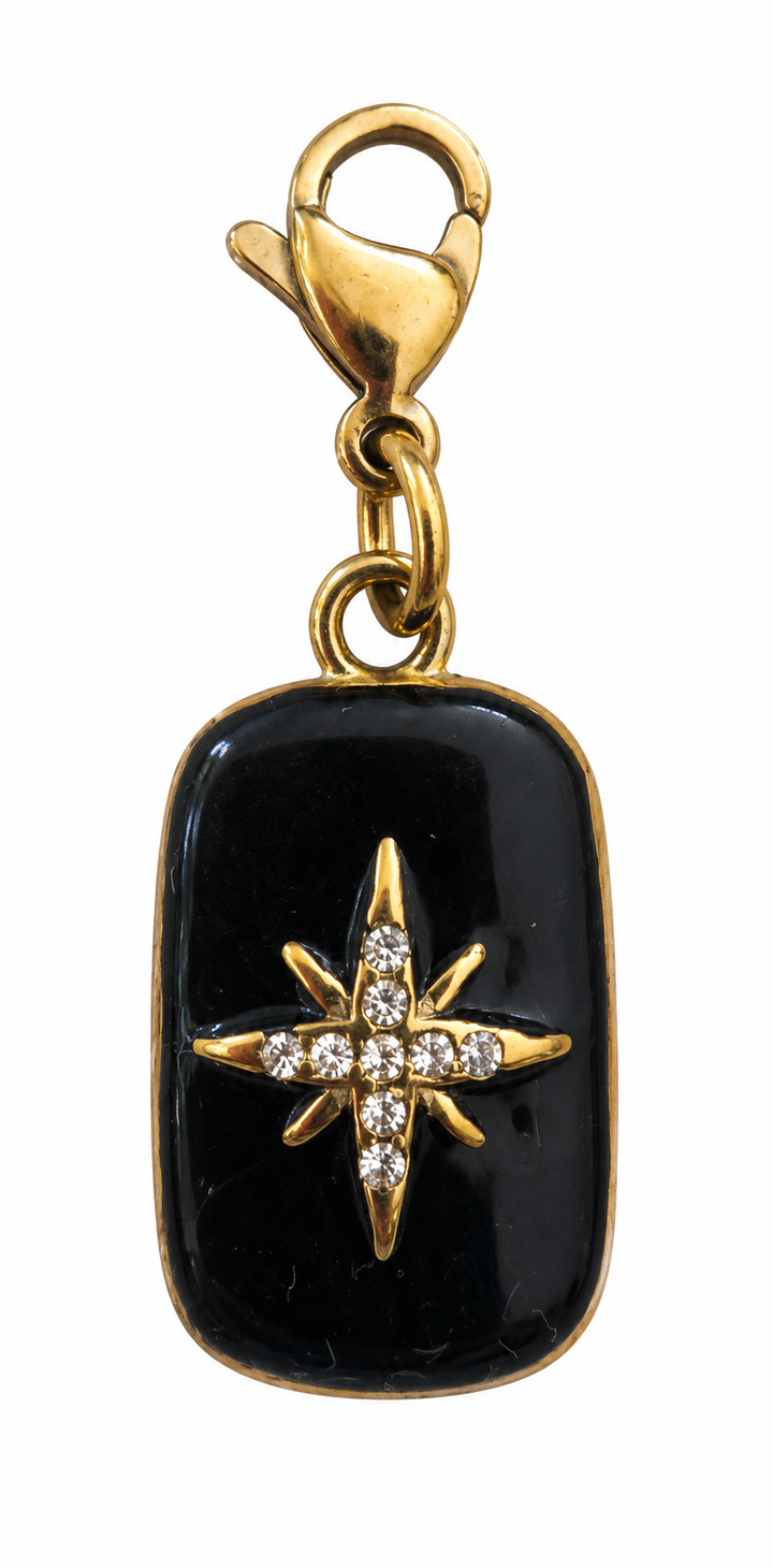 a black and gold pendant with diamonds
