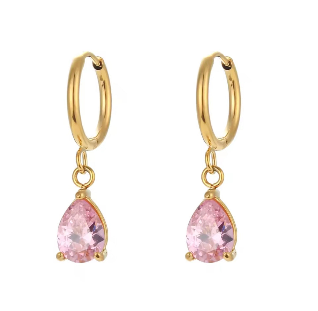 a pair of gold hoop earrings with pink gemstones