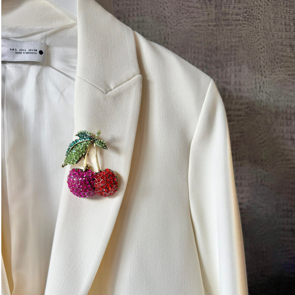a white jacket with a brooch on it